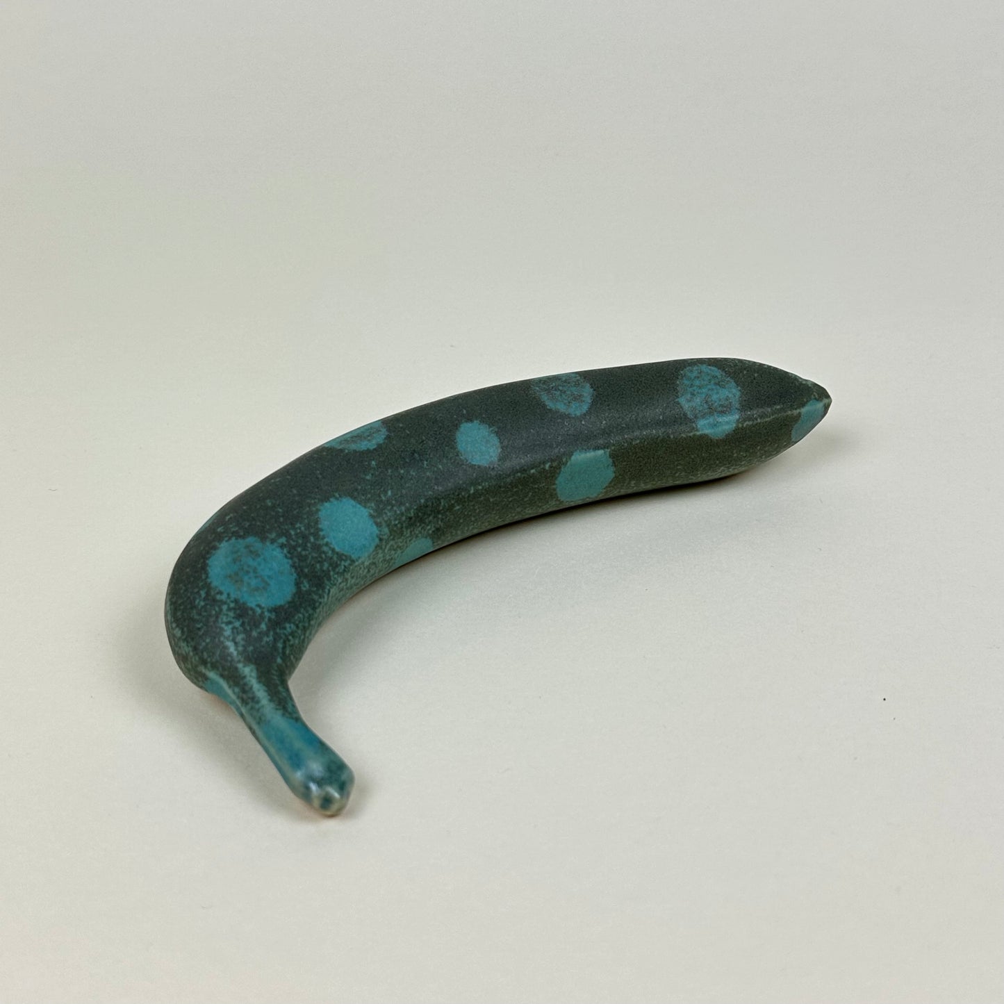 Spotted turquoise and dark green stoneware banana by Malwina Kleparska