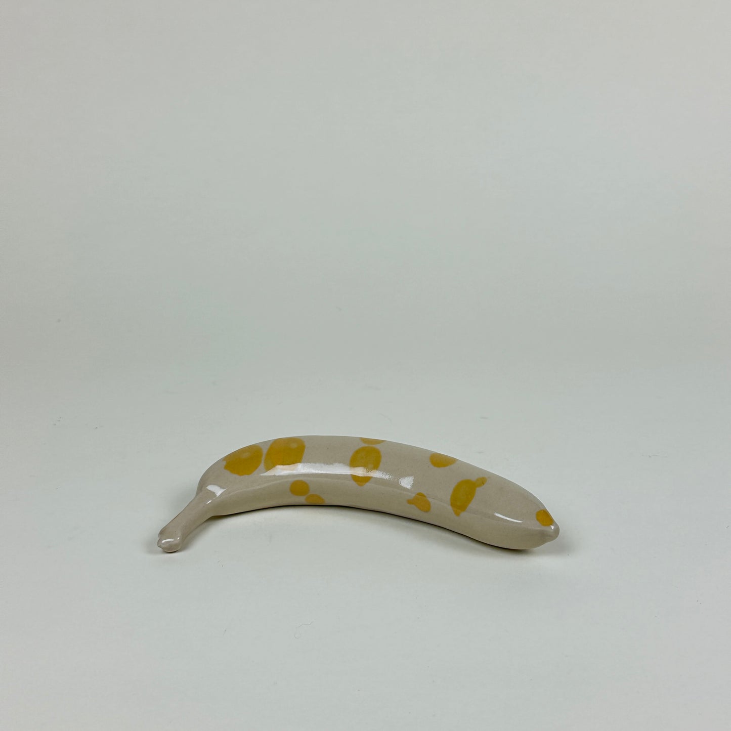 Yellow spotted stoneware banana by Malwina Kleparska
