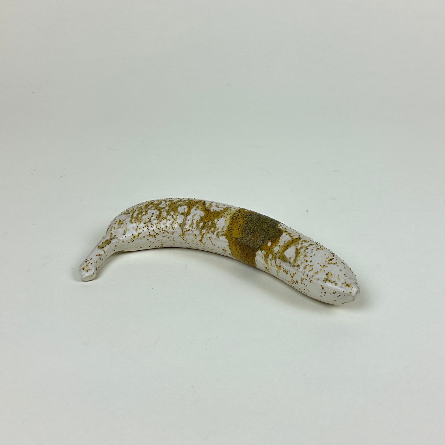 Yellow/brown stained stoneware banana by Malwina Kleparska