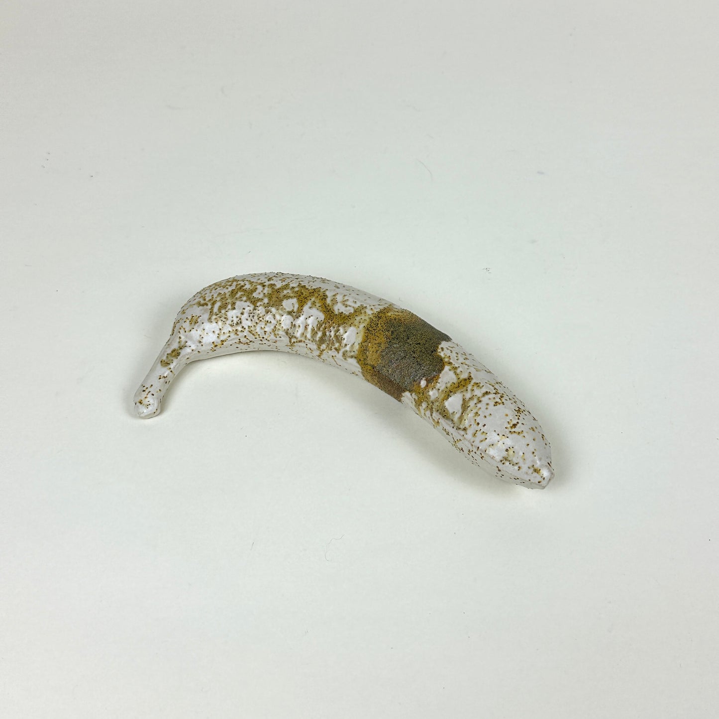 Yellow/brown stained stoneware banana by Malwina Kleparska