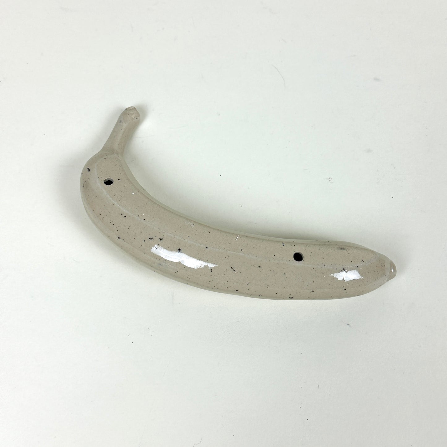 Off white stoneware banana with small black speckles by Malwina Kleparska