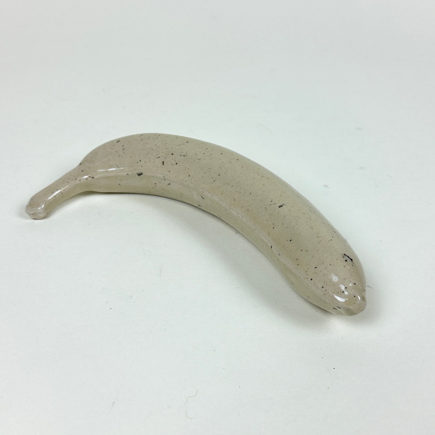 Off white stoneware banana with small black speckles by Malwina Kleparska