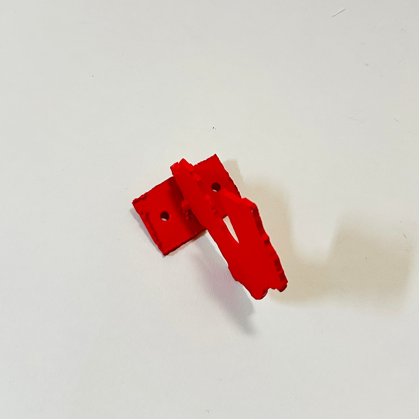 Red metal wall hook by Lisa Reiser