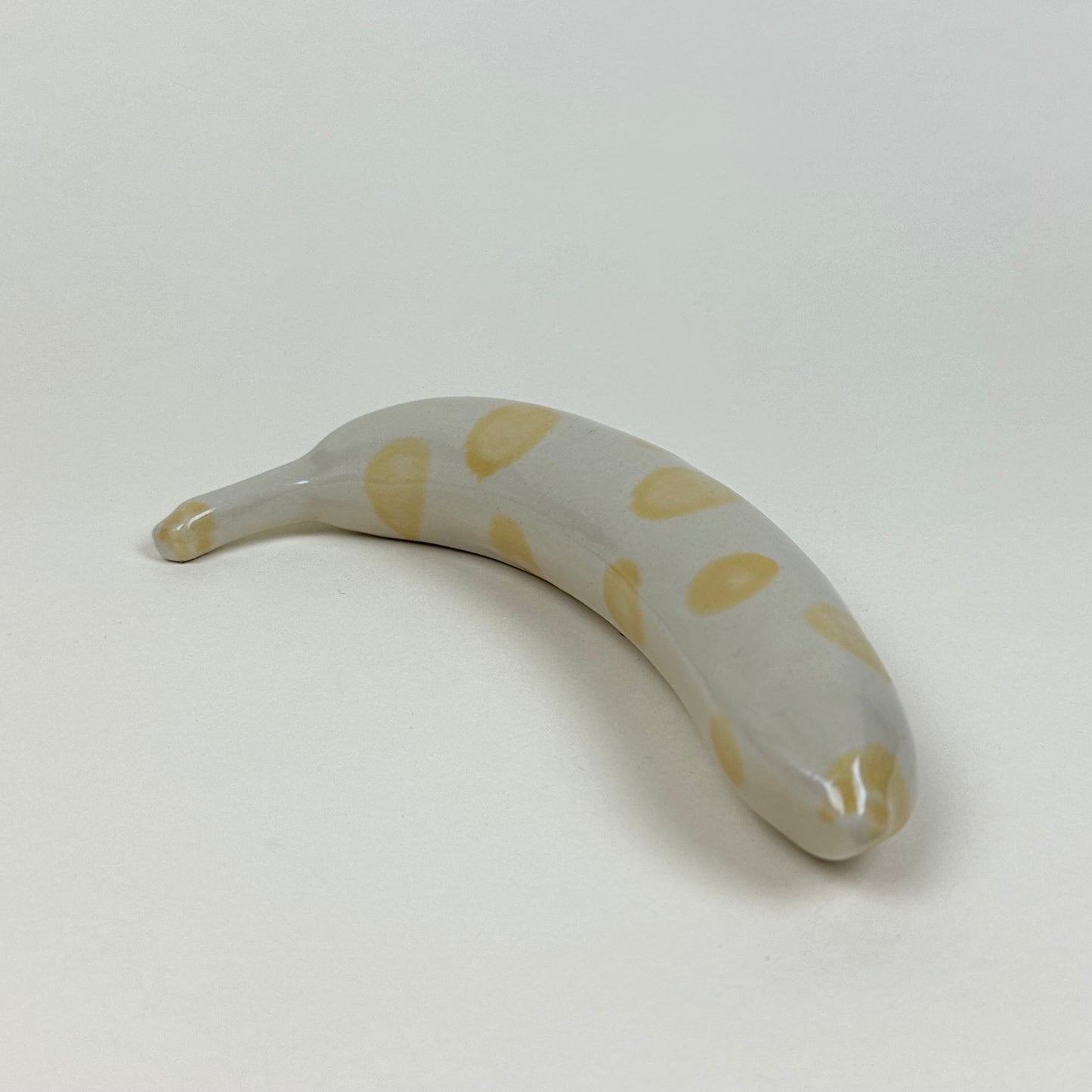 Spotted yellow and white stoneware banana by Malwina Kleparska