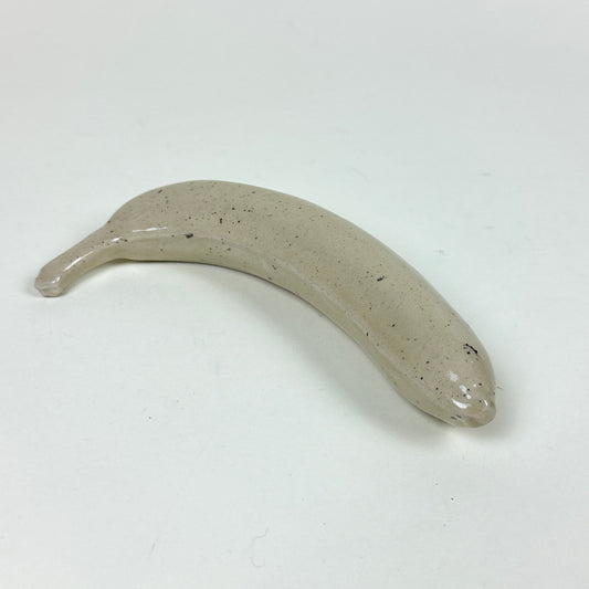 Off white stoneware banana with small black speckles by Malwina Kleparska